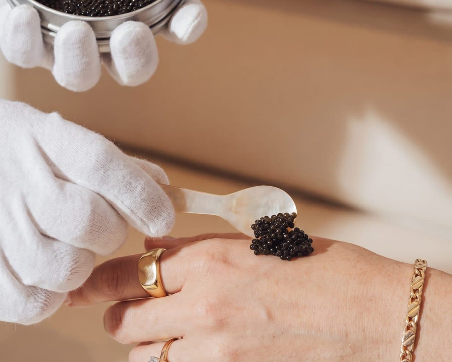 Caviar served onto the back of the hand with a mother of pearl spoon