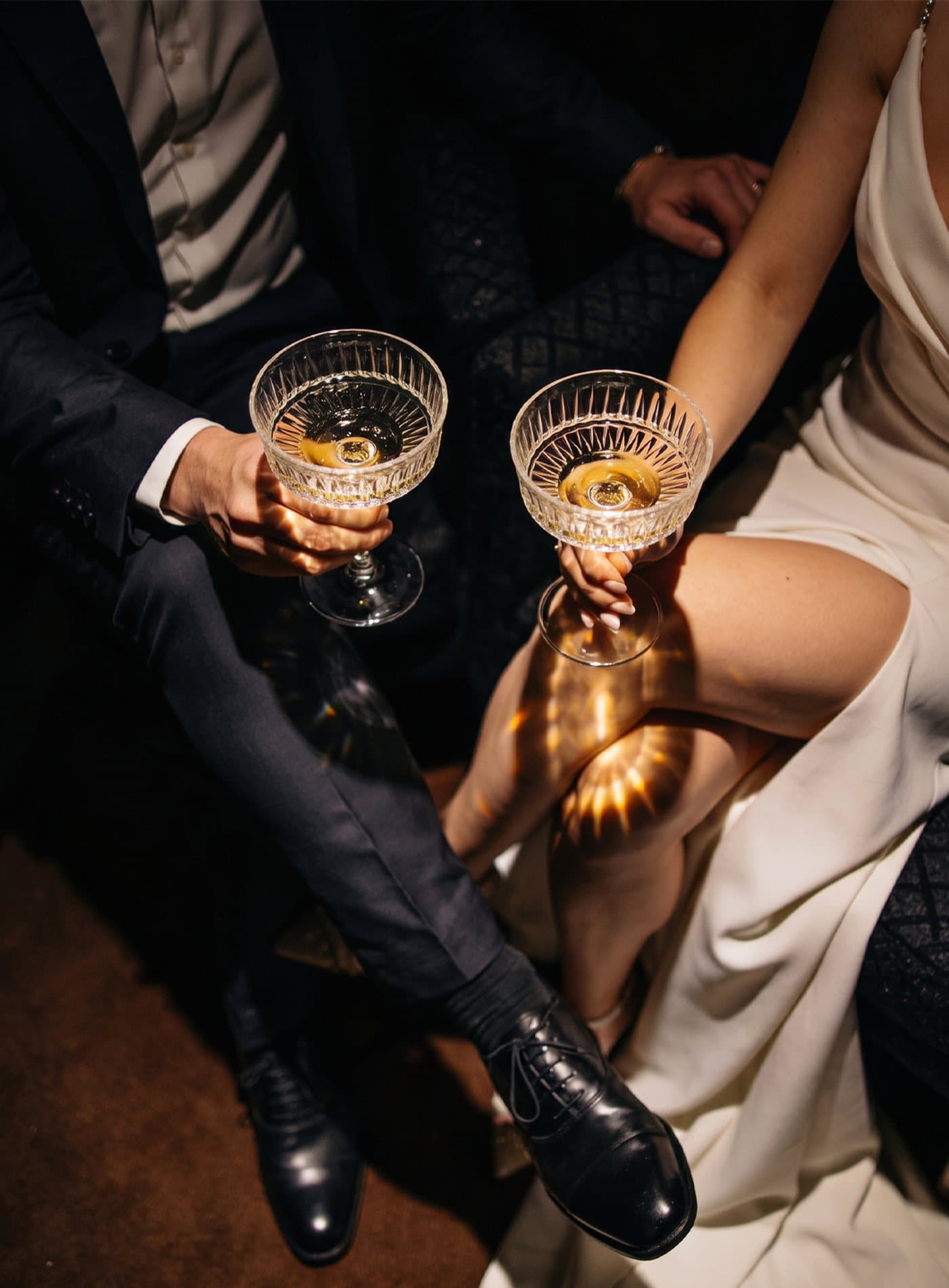 A couple touching coupes in a toast at a reception