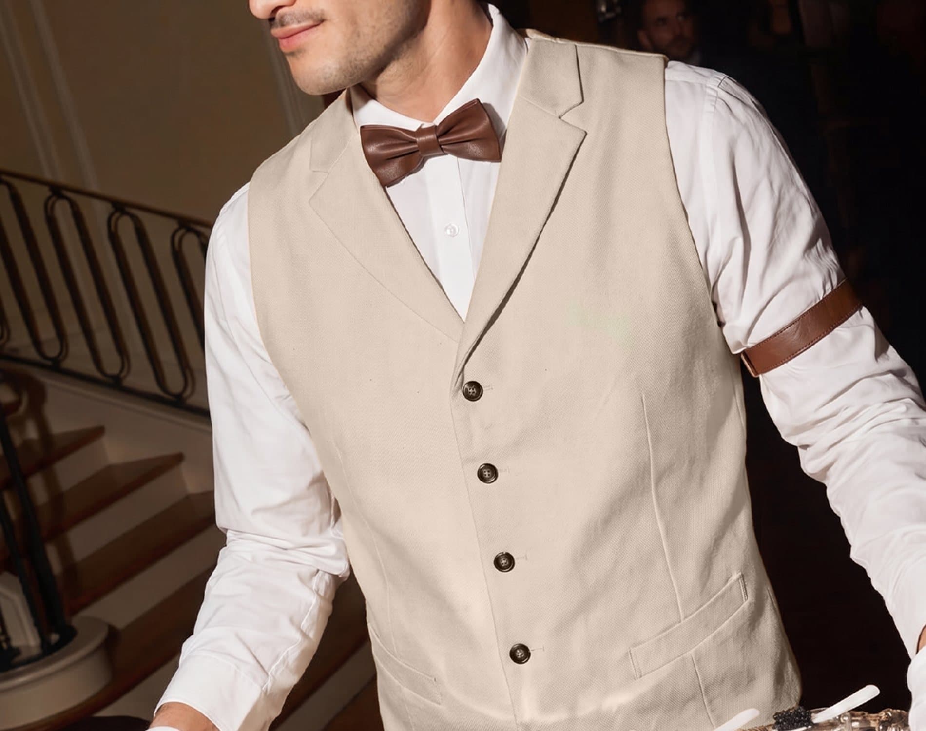 A server in a waistcoat and white gloves presenting a tray of caviar canapes